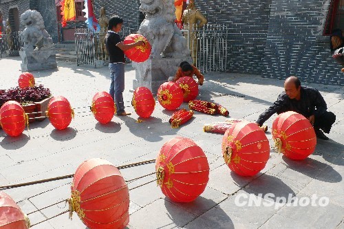 8月31日，河南省開(kāi)封市天波楊府門口，工作人員在準(zhǔn)備懸掛大紅燈籠。隨著“十一”國(guó)慶節(jié)和“十一”旅游黃金周的臨近，古城開(kāi)封的公園景點(diǎn)已早早開(kāi)始備戰(zhàn)，營(yíng)造喜慶祥和的旅游環(huán)境，迎接八方客人。 中新社發(fā) 李俊生 攝