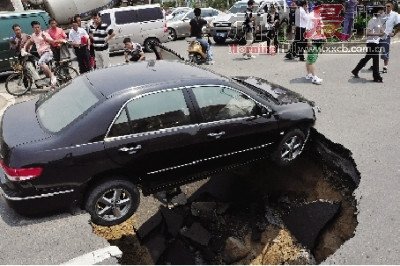 4日，南昌市昌南大道與迎賓北大道交叉口附近路面突然發(fā)生塌陷，一輛過路小轎車被卡在洞口處。圖/新華社