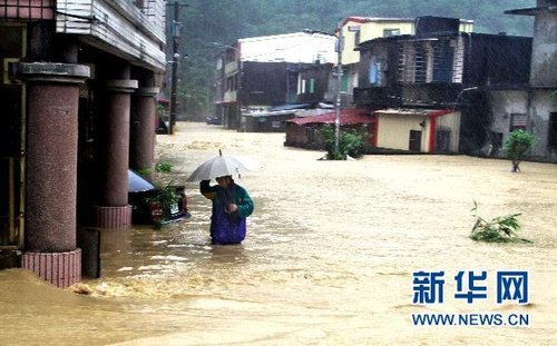 10月21日，臺灣宜蘭縣蘇澳地區(qū)居民在洪水中艱難出行。新華社發(fā) 