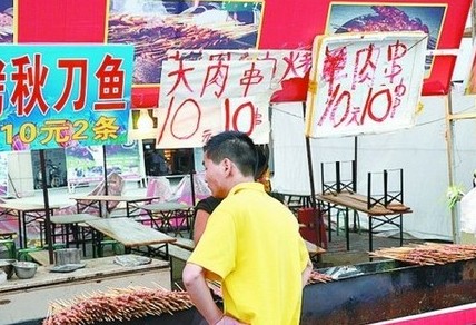 被查后，美食街上的'羊肉串'的'羊'字被涂抹了。