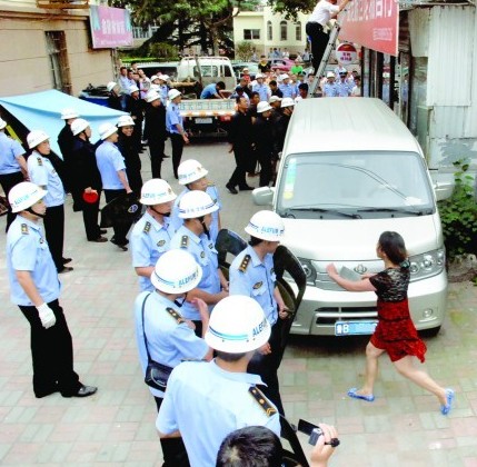 青島彪悍女揮斧頭菜刀阻強拆 城管站一排舉盾牌