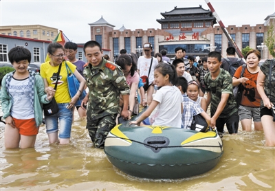 昨日，消防戰(zhàn)士在秦皇島市山海關(guān)火車站涉水運送旅客。當日，受持續(xù)強降雨影響，河北省秦皇島市海港區(qū)、山海關(guān)區(qū)等地出現(xiàn)內(nèi)澇，部分列車停運。 新華社發(fā)