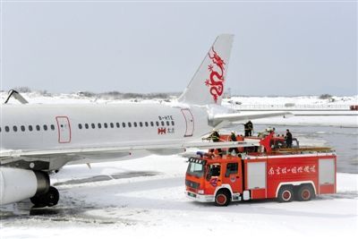 2月19日，南京祿口國際機場工作人員在清理飛機上的積雪。新華社發(fā)